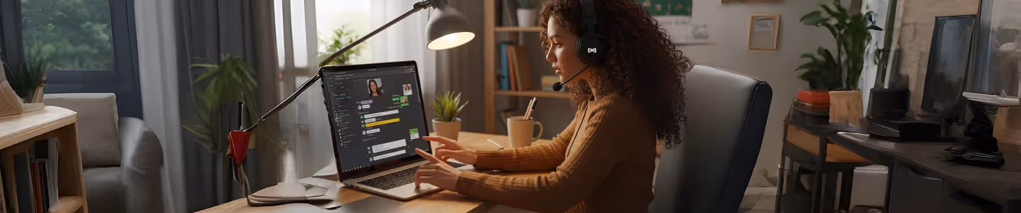 Mulher em home office com headset e notebook.
