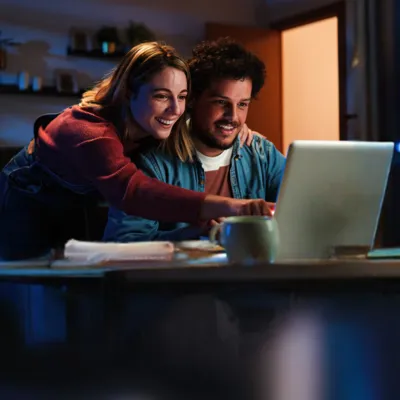 Casal pesquisando no computador maneiras de conseguir internet grátis.