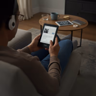 Homem usando tablet para assistir conteúdo enquanto ouve música com fones de ouvido.