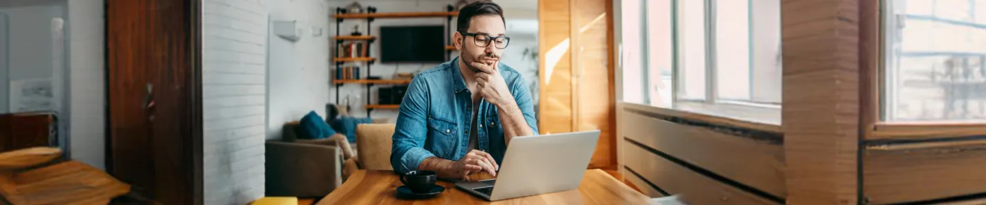 Homem pesquisa no notebook como medir a velocidade da internet.