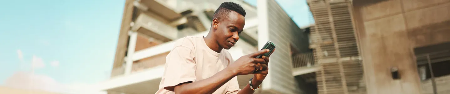 Homem sentado usando o celular.