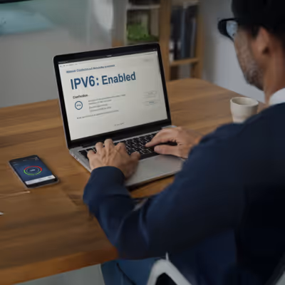 Usuário gerencia conexão IPv6 ativada no laptop com smartphone ao lado