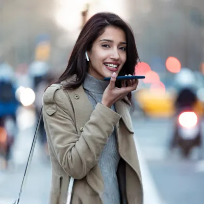 Mulher acessando o assistente de voz com Wi-Fi público na rua.