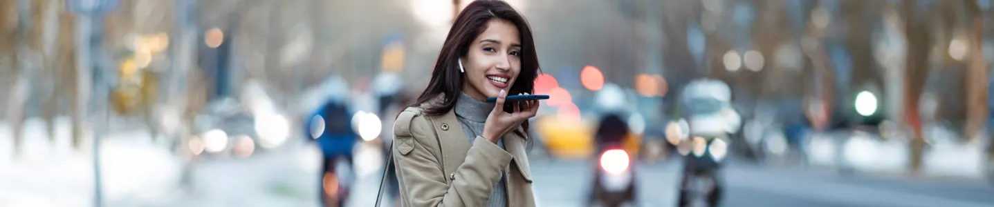 Mulher usando o assistente de voz com Wi-Fi público na rua.