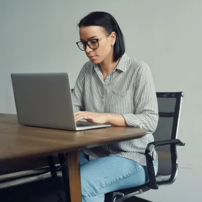 Telegram Web sendo usado por mulher sentada no notebook.