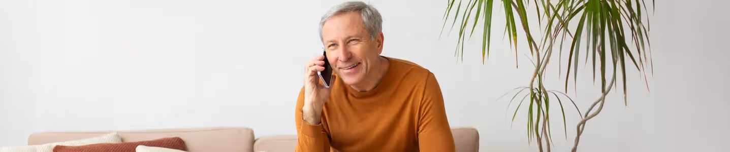 Senhor feliz conversando ao celular.