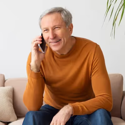 Senhor sorridente falando no celular.
