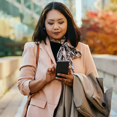 A mulher verifica em seu celular os códigos DDD de cada estado, procurando identificar os prefixos telefônicos correspondentes a diferentes regiões do país.