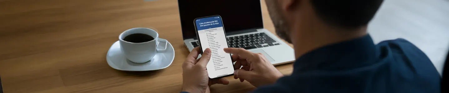 Pessoa consulta lista atualizada de DDI dos países da Europa no celular.