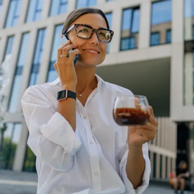 Conversa no smartphone enquanto toma café.