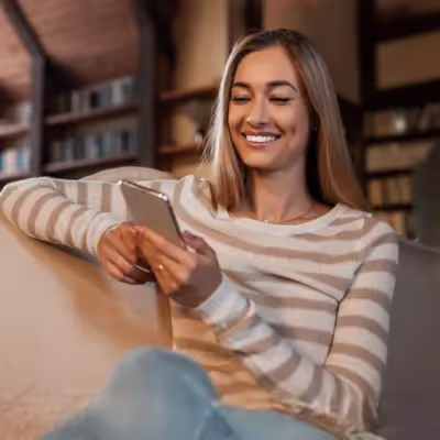 Mulher pesquisando no celular as melhores dicas de fibra.