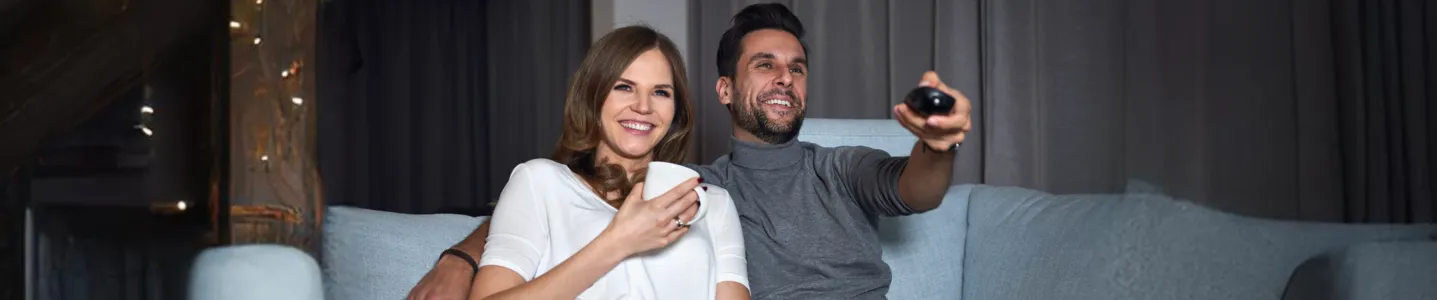 Casal assistindo streaming na TV.