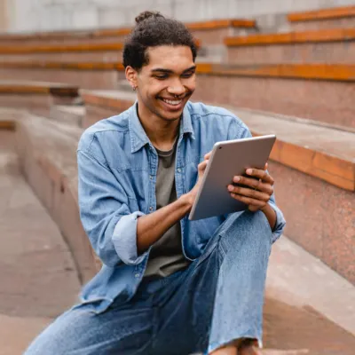 Homem lendo seu best-seller favorito no tablet pelo "Livros Skeelo".