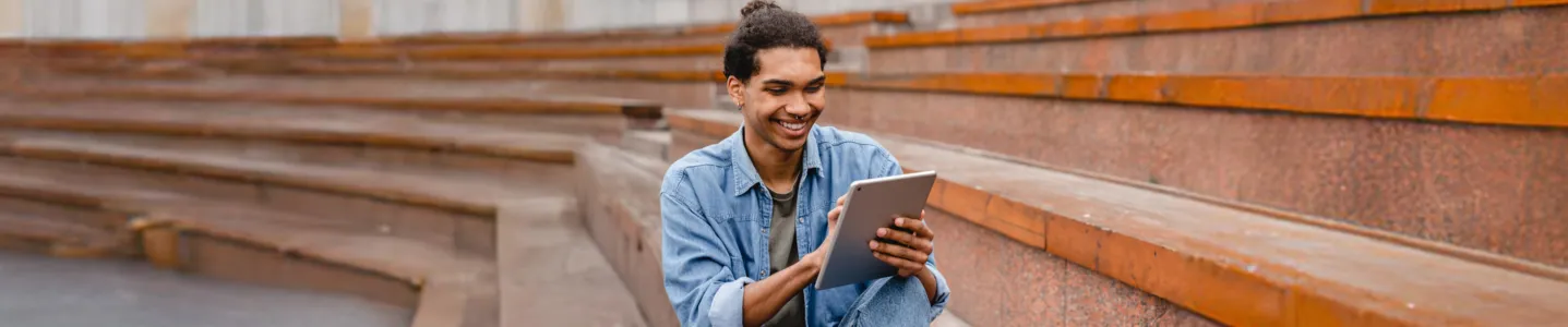 Homem lendo seu best-seller favorito pelo "Livros Skeelo" no tablet.