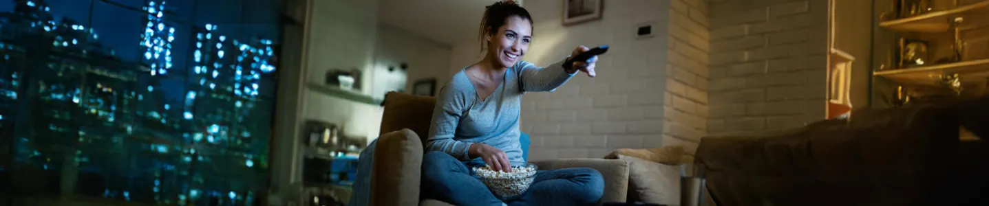 Mulher assistindo Max no sofá da sala.