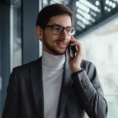 O empresário está focado e determinado durante a ligação de negociação, demonstrando sua habilidade e expertise para alcançar acordos favoráveis aos negócios.