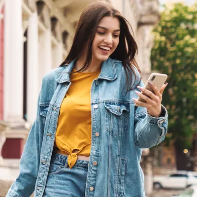 A jovem mulher está explorando seu celular, experimentando a nova Fibra da Oi, que promete revolucionar sua conexão de internet com velocidade e confiabilidade excepcionais.