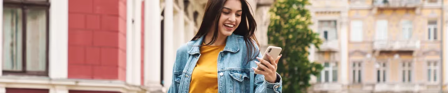 Uma jovem mulher está mexendo no celular, experimentando a nova Fibra da Oi, que veio para revolucionar sua experiência na internet, proporcionando velocidade e estabilidade incomparáveis.