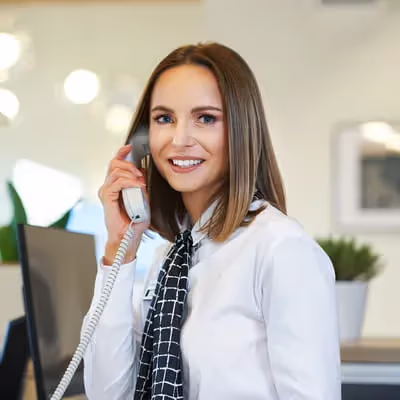 Profissional da Oi atende o telefone com cordialidade e disposição para resolver as necessidades dos clientes da empresa.