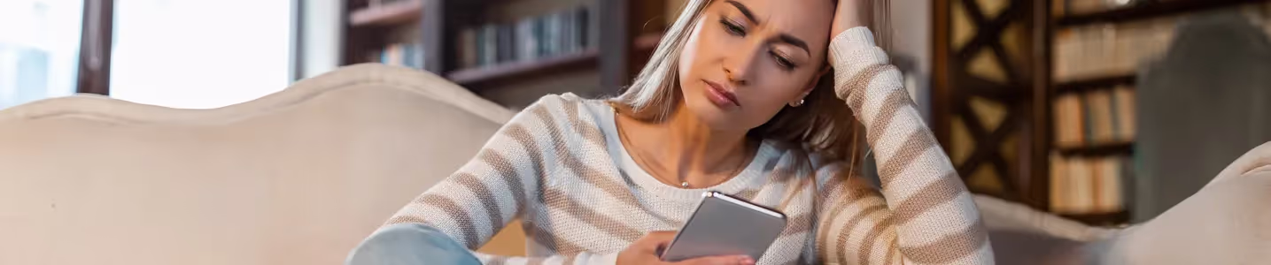 Mulher frustrada ao ver a mensagem "Não Registrado na Rede" em seu celular.