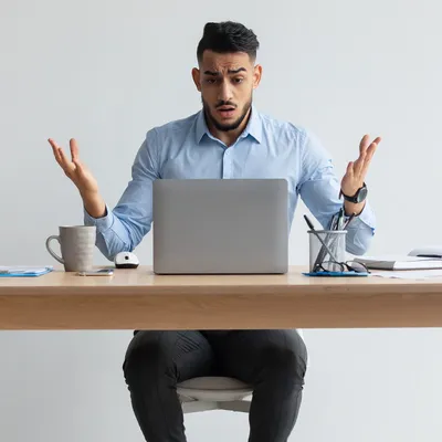 Com expressão confusa, um homem olha para o laptop sem conexão à internet, abrindo as mãos em perplexidade. A frustração é evidente, enquanto ele tenta resolver a questão e restaurar a conexão para retomar suas atividades online.