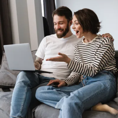 Casal analisando as opções de planos de internet Oi Fibra no notebook.