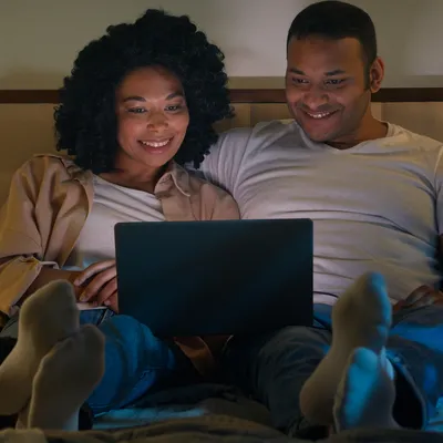 Entre sorrisos compartilhados, o casal se deleita ao desfrutar do Oi Controle pelo notebook, aproveitando as facilidades proporcionadas pelo serviço para suas atividades online.