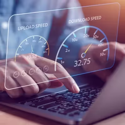 Concentrado em seu notebook, um homem trabalha enquanto uma janela flutuante revela velocidades impressionantes de download e upload, evidenciando uma conexão ágil e eficiente.
