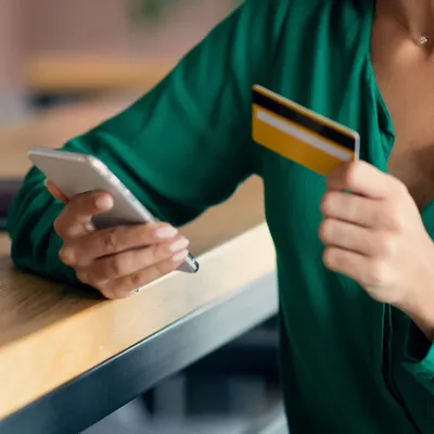 De maneira tranquila, uma mulher está negociando com a Oi pelo seu próprio celular para regularizar suas contas atrasadas, demonstrando autonomia e controle sobre suas finanças pessoais.