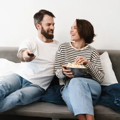 Casal vendo os melhores filmes na televisão.