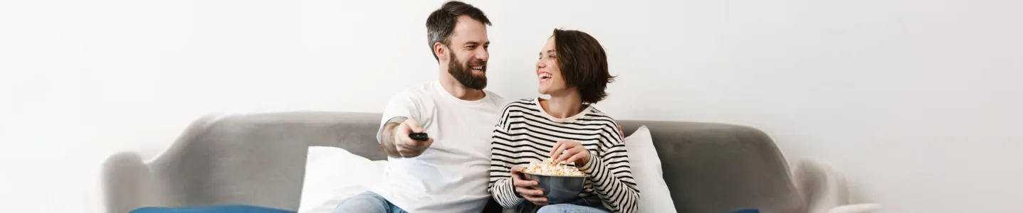 Casal assistindo os melhores filmes na TV.