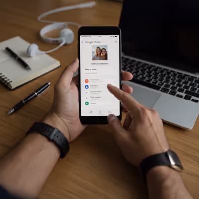 Configuração do Google Photos no celular ao lado de laptop