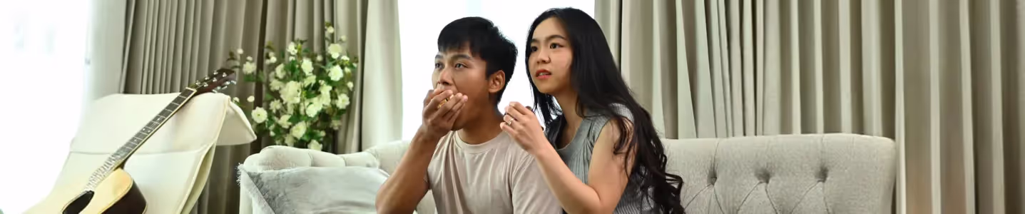 Casal assistindo dorama na TV juntos.