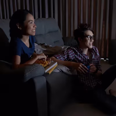 Casal curtindo uma série na televisão.