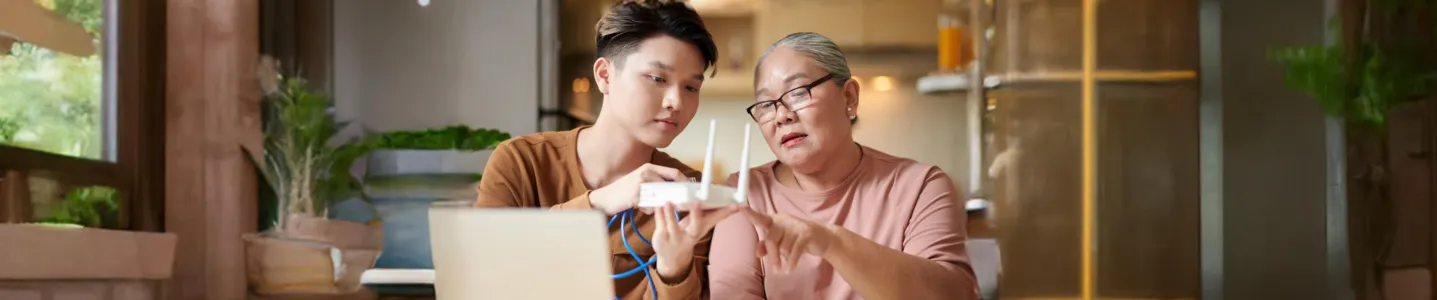 Jovem e senhora vendo funções avançadas do roteador.