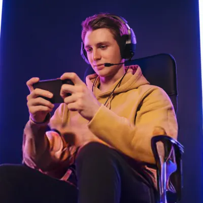 Jovem se divertindo com Minecraft no celular.