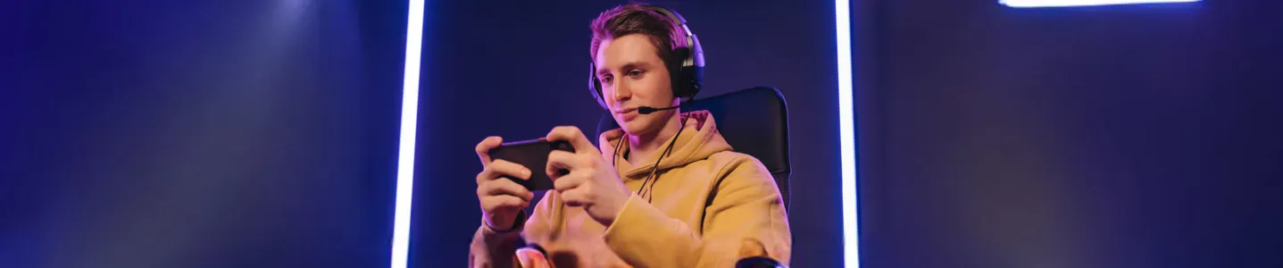 Jovem jogando Minecraft no celular.