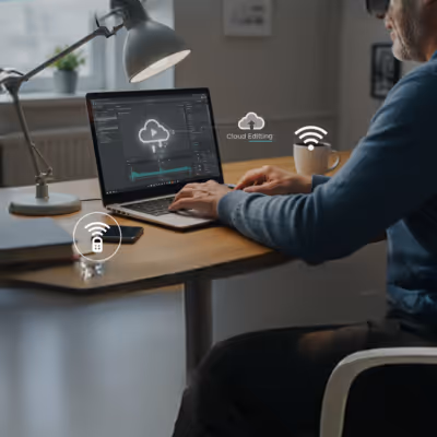 Pessoa trabalhando no laptop com ícones de nuvem e conectividade.