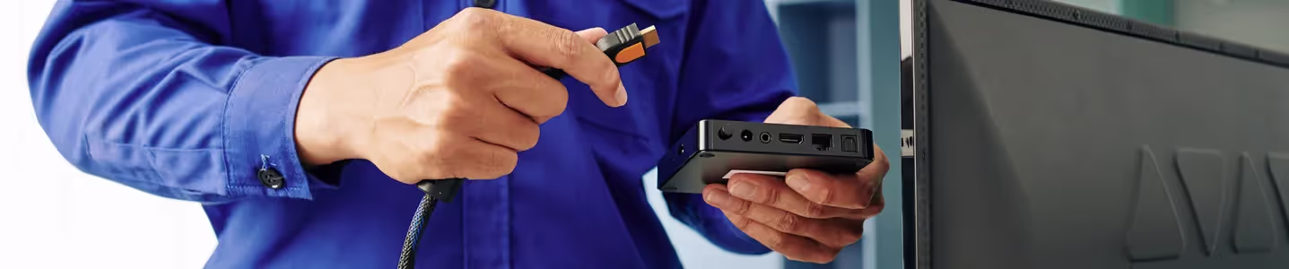 Com atenção e cuidado, um rapaz instala o receptor da Oi TV em sua televisão, preparando-se para desfrutar dos serviços oferecidos pela operadora e explorar uma variedade de opções de entretenimento.