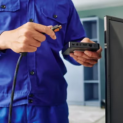 De forma meticulosa, um rapaz conecta o receptor da Oi TV à sua televisão, ansioso para explorar as opções de entretenimento oferecidas pela operadora e garantir uma experiência audiovisual agradável.