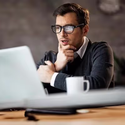 Um jovem está consultando em seu notebook qual a quantidade ideal de megabits de internet, buscando determinar o plano mais adequado para suas atividades online.