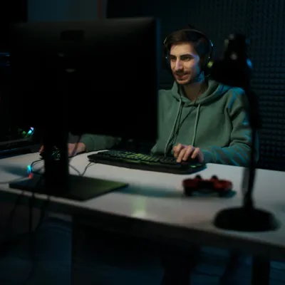 Homem se divertindo jogando League of Legends no PC.