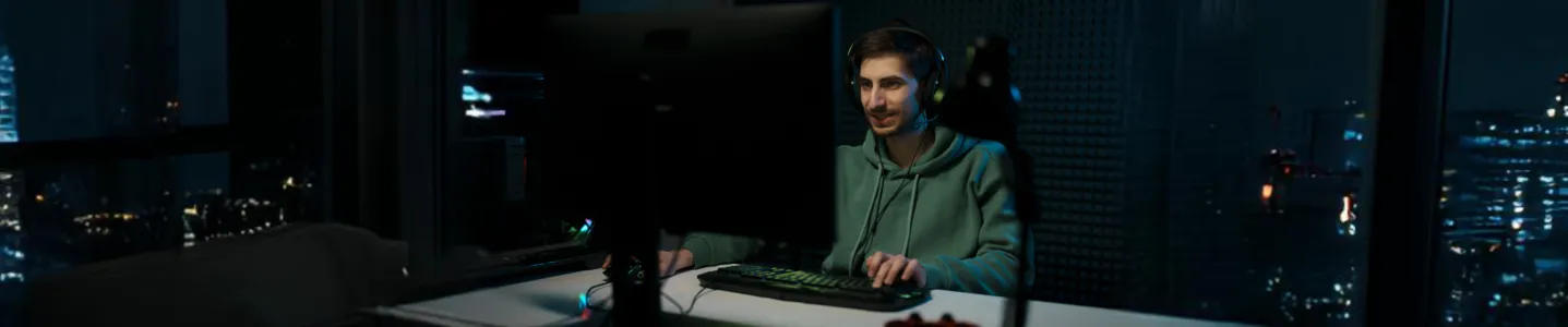 Homem jogando LoL intensamente no computador.