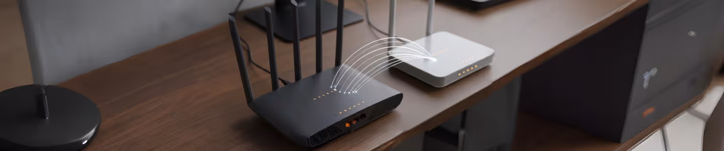 Dois roteadores conectados entre si em mesa de escritório