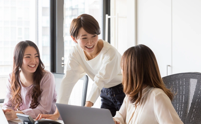 Three woman in office working and smiling