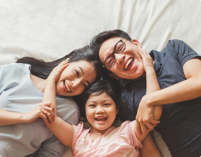 Happy family on bead, woman, little girl and a man