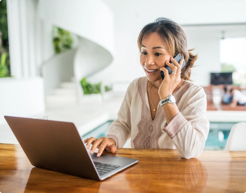 Woman talking over the phone, working on laptop
