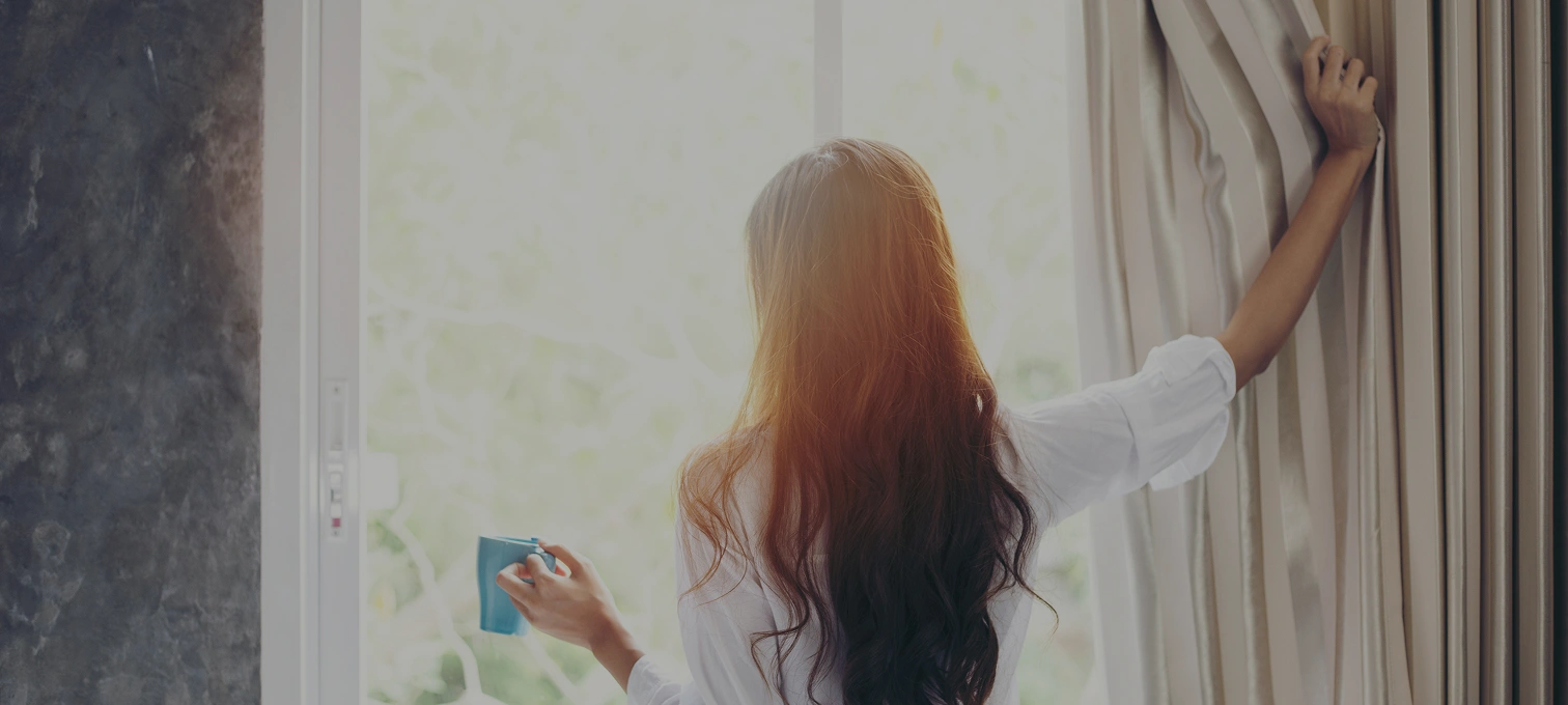 Woman with a cup, near window