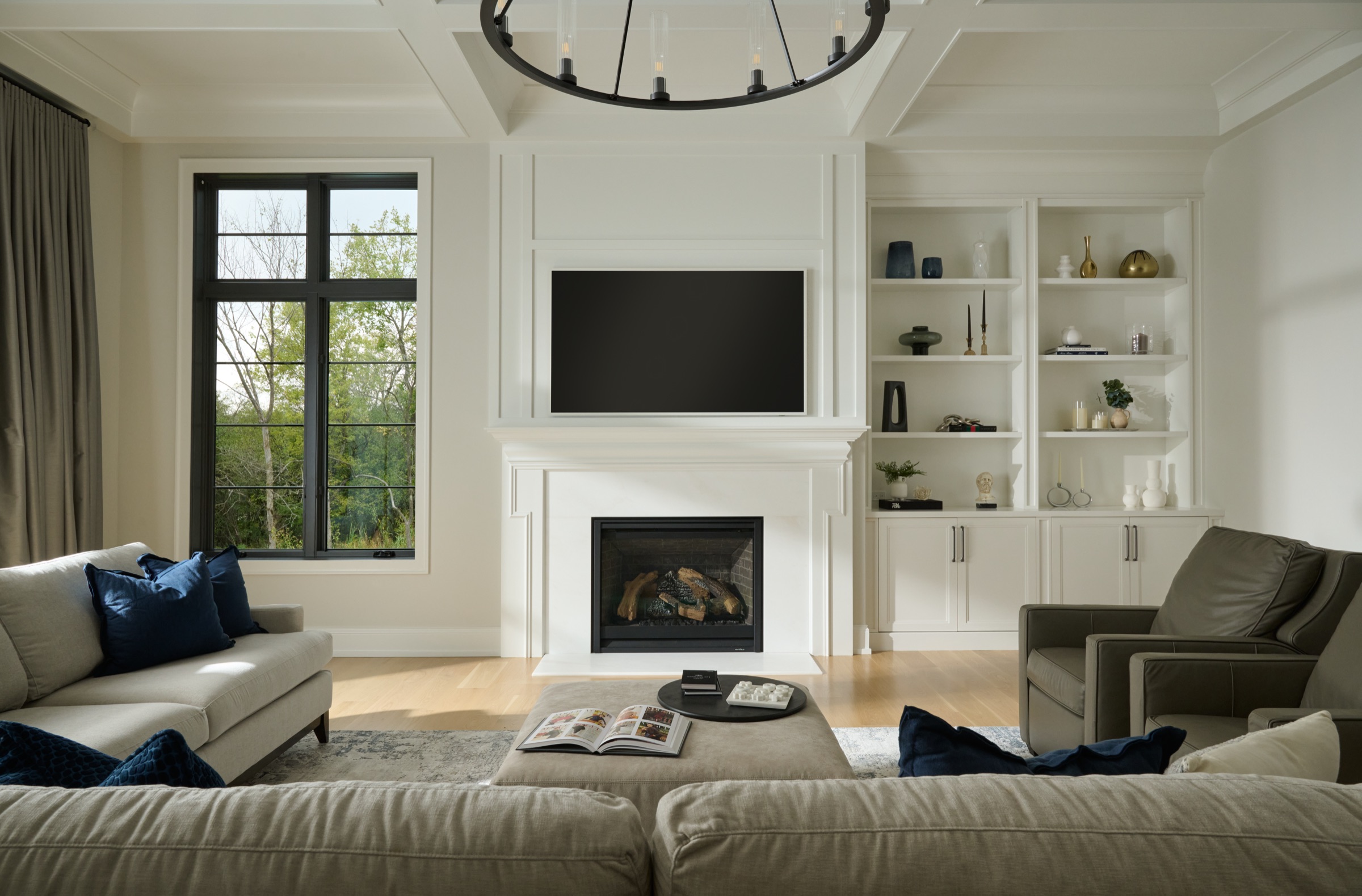 A closer view of the great room fireplace, white mantel, and custom built-ins beneath the coffered ceiling.