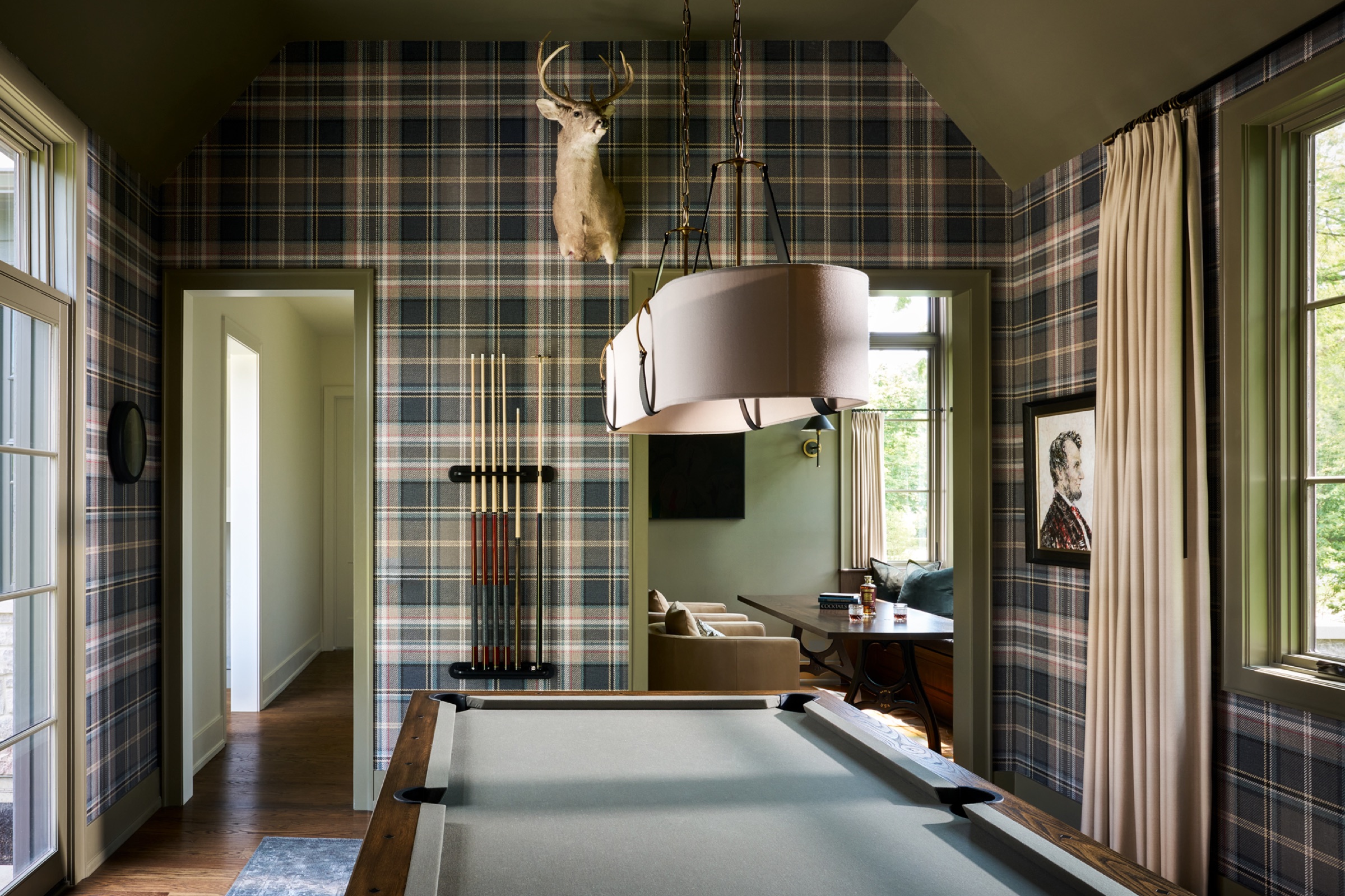 An impressive billiards room leading out to a hidden speakeasy filled with custom-designed built-in cabinetry and a bench seating area.